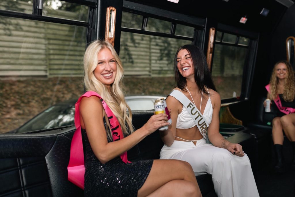 Two women enjoying champagne aboard the Party Bus